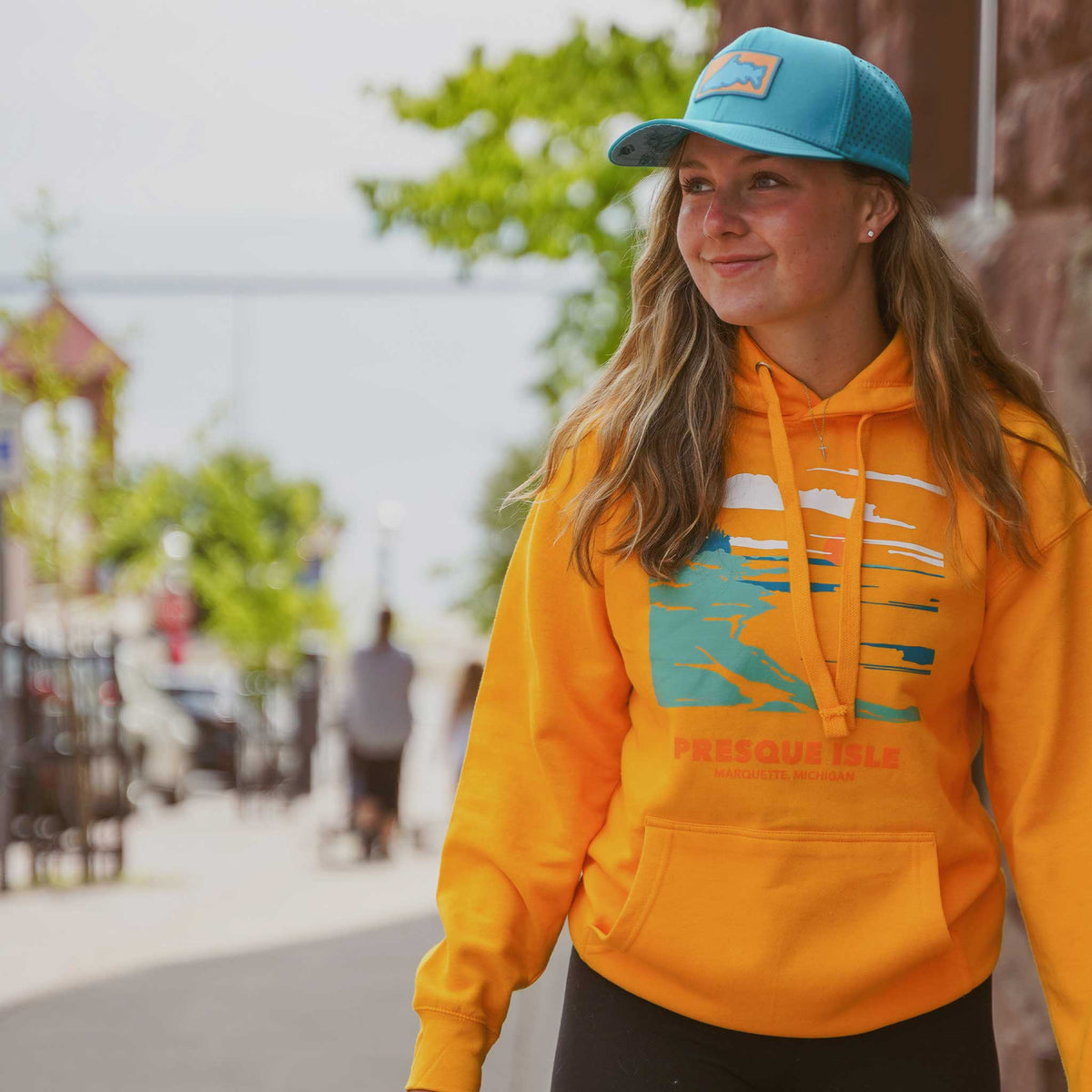 a woman wearing a blue hat and yellow sweatshirt